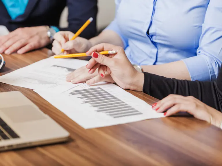 Advogados analisando documentos e gráficos sobre direitos trabalhistas, representando assessoria jurídica em questões como rescisões, horas extras, adicionais e ações trabalhistas.